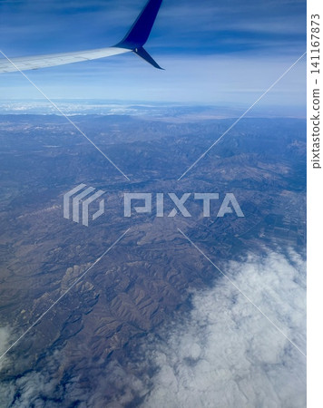 Mountain ranges and a beautiful sea of clouds viewed from the window of an airplane. Mountain ranges and a beautiful sea of clouds viewed from the window of an airplane. 141167873