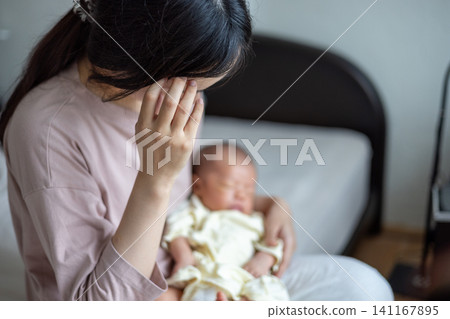 一位剛生完孩子、筋疲力盡的新手媽媽抱著她的寶寶。 一位剛生完孩子、筋疲力盡的新手媽媽抱著她的寶寶。 141167895