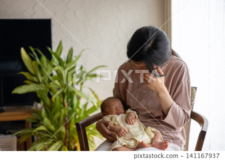 一位剛生完孩子、筋疲力盡的新手媽媽抱著她的寶寶。 一位剛生完孩子、筋疲力盡的新手媽媽抱著她的寶寶。 141167937