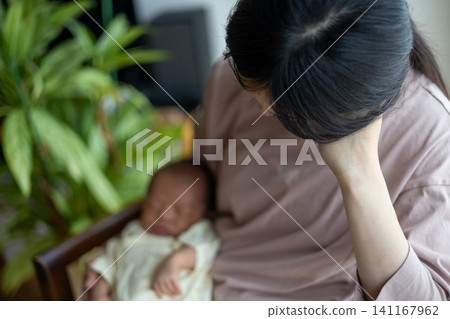 A new mother, exhausted after childbirth, holding her baby. A new mother, exhausted after childbirth, holding her baby. 141167962