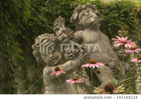 Angel statues and a garden in bloom with echinacea Angel statues and a garden in bloom with echinacea 141168124