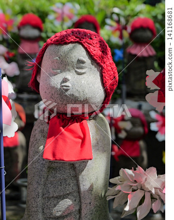 Cute Jizo statues wearing red hats line the streets of Zojoji Temple amidst the fresh greenery. Cute Jizo statues wearing red hats line the streets of Zojoji Temple amidst the fresh greenery. 141168681