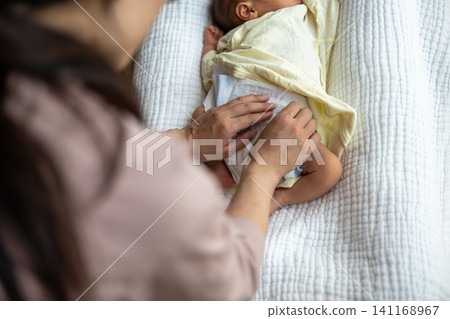 給新生兒換尿布。 給新生兒換尿布。 141168967