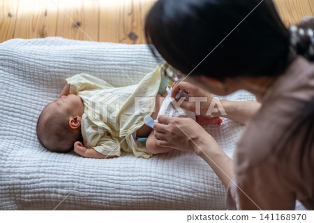 給新生兒換尿布。 給新生兒換尿布。 141168970