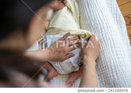 給新生兒換尿布。 給新生兒換尿布。 141168976