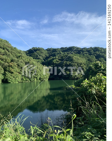 寧靜的湖泊,周圍環繞著初夏湛藍的天空和鬱鬱蔥蔥的青山。 寧靜的湖泊,周圍環繞著初夏湛藍的天空和鬱鬱蔥蔥的青山。 141169250
