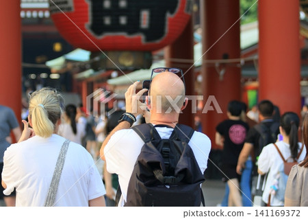 Foreign tourists taking photos of Sensoji Temple with their smartphones Foreign tourists taking photos of Sensoji Temple with their smartphones 141169372