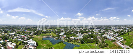 Aerial panoramic drone view of suburban residential areas, green fields, farmland, and a wide blue sky on a sunny day Aerial panoramic drone view of suburban residential areas, green fields, farmland, and a wide blue sky on a sunny day 141170135