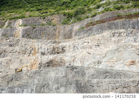 石灰岩採石場的景觀,巨大的岩壁和一台挖土機(2) 石灰岩採石場的景觀,巨大的岩壁和一台挖土機(2) 141170258
