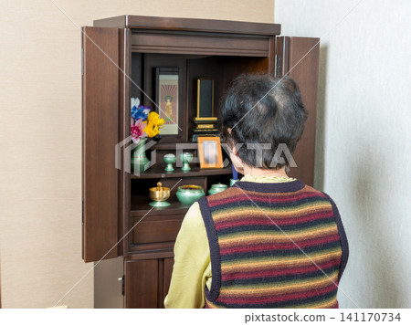 The back view of an elderly woman facing the Buddhist altar. The back view of an elderly woman facing the Buddhist altar. 141170734
