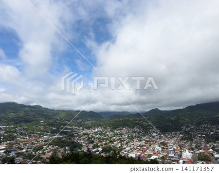 View of town and mountains under cloudy sky in daytime View of town and mountains under cloudy sky in daytime 141171357