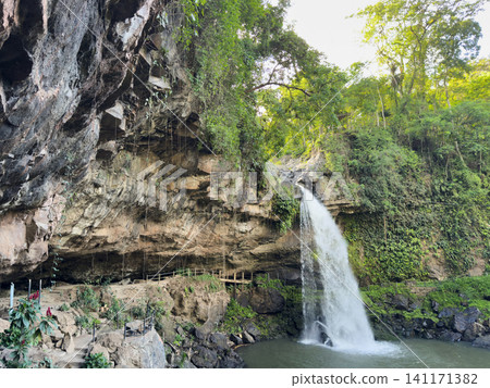 Waterfall flows from rocks in tropical forest during daytime 141171382