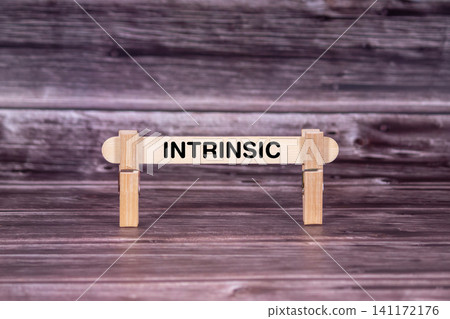 Intrinsic symbol. Wooden stick held by Clothespins, beautiful Realistic Grunge Wooden Background. Business and Intrinsic concept with copy space Intrinsic symbol. Wooden stick held by Clothespins, beautiful Realistic Grunge Wooden Background. Business and Intrinsic concept with copy space 141172176
