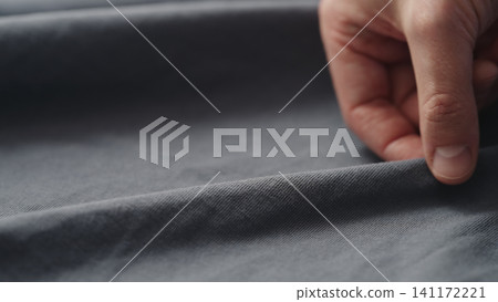 man manually check gray blue color cotton fabric for clothing with hands man manually check gray blue color cotton fabric for clothing with hands 141172221