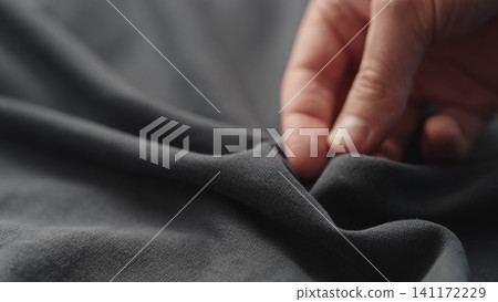 man manually check gray color cotton fabric for clothing with hands man manually check gray color cotton fabric for clothing with hands 141172229