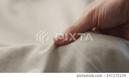 man manually check ivory color cotton fabric for clothing with hands man manually check ivory color cotton fabric for clothing with hands 141172234