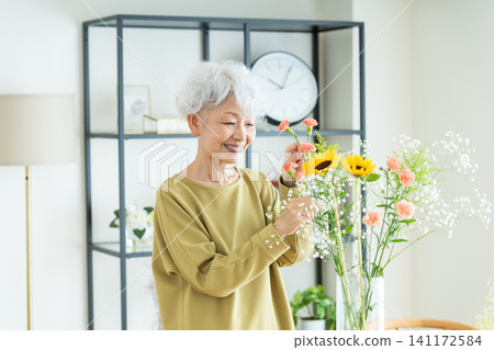 一位老婦人在家插花 一位老婦人在家插花 141172584