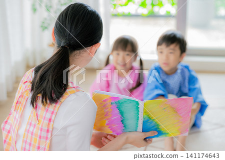 A nursery teacher who reads a picture book A nursery teacher who reads a picture book 141174643