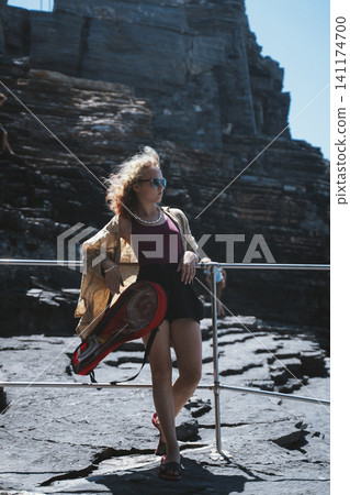 Teen Girl Relaxing with Badminton Racket in Scenic Area Teen Girl Relaxing with Badminton Racket in Scenic Area 141174700