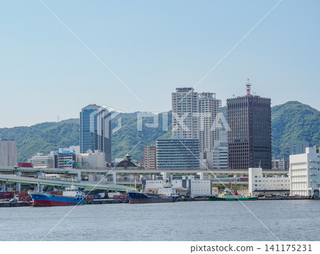 The buildings of Kobe city and Mount Rokko as seen from a sightseeing boat in Kobe Port. The buildings of Kobe city and Mount Rokko as seen from a sightseeing boat in Kobe Port. 141175231