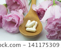 Beauty supplements and a bouquet of pink flowers 141175309