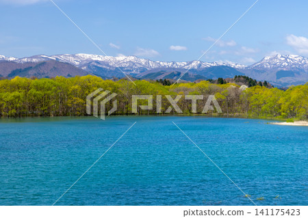 從岩手縣岩手郡雫石町雫石河公園毗鄰禦所湖的山頂上,可以看到湖面藍色的湖面上遠處白雪皚皚的群山,包括秋田駒岳。 從岩手縣岩手郡雫石町雫石河公園毗鄰禦所湖的山頂上,可以看到湖面藍色的湖面上遠處白雪皚皚的群山,包括秋田駒岳。 141175423