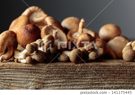 Fresh shiitake and shimeji mushrooms on an old wooden table. Fresh shiitake and shimeji mushrooms on an old wooden table. 141175445