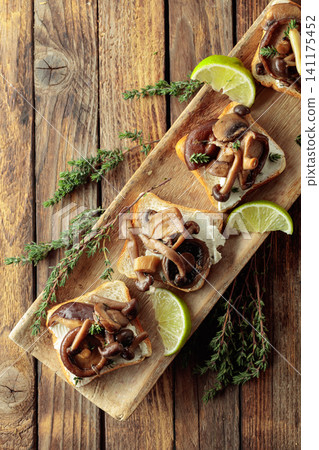Sandwiches with baked mushrooms on an old wooden table. Sandwiches with baked mushrooms on an old wooden table. 141175452