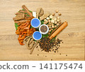 Top view of traditional Thai herbal ingredients for inhalers, including cloves, borneol, menthol, nutmeg, agarwood, black pepper, and camphor, arranged on a rustic wooden background, showcasing natura 141175474