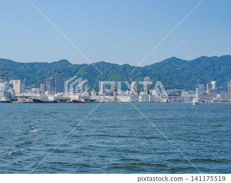 The buildings of Kobe city and Mount Rokko as seen from a sightseeing boat in Kobe Port. 141175519