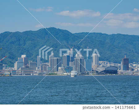 The buildings of Kobe city and Mount Rokko as seen from a sightseeing boat in Kobe Port. The buildings of Kobe city and Mount Rokko as seen from a sightseeing boat in Kobe Port. 141175661