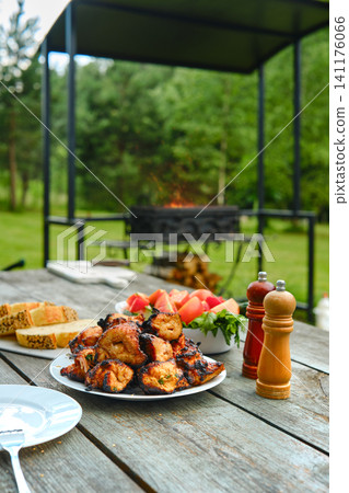 Barbecue gathering in backyard with grilled chicken, tomato and cucumber salad and bread Barbecue gathering in backyard with grilled chicken, tomato and cucumber salad and bread 141176066