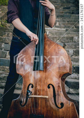 View of musician playing contrabass at the street. Musical Instrument View of musician playing contrabass at the street. Musical Instrument 141176197