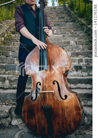 View of musician playing contrabass at the street. Musical Instrument View of musician playing contrabass at the street. Musical Instrument 141176198