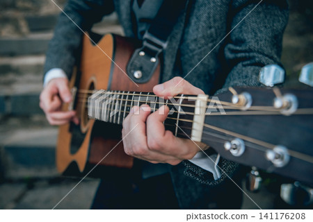 Man's hands playing acoustic guitar. Background Man's hands playing acoustic guitar. Background 141176208