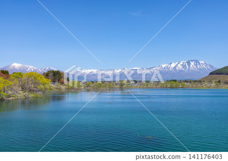 From the Motogosho Bridge over Lake Gosho, a reservoir on the Shizukuishi River in Shizukuishi Town, Iwate District, Iwate Prefecture, you can see the snow-capped Mt. Iwate and Mt. Takakura across the blue surface of the lake. From the Motogosho Bridge over Lake Gosho, a reservoir on the Shizukuishi River in Shizukuishi Town, Iwate District, Iwate Prefecture, you can see the snow-capped Mt. Iwate and Mt. Takakura across the blue surface of the lake. 141176403