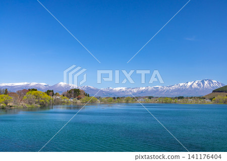 From the Motogosho Bridge over Lake Gosho, a reservoir on the Shizukuishi River in Shizukuishi Town, Iwate District, Iwate Prefecture, you can see the snow-capped Mt. Iwate and Mt. Takakura across the blue surface of the lake. From the Motogosho Bridge over Lake Gosho, a reservoir on the Shizukuishi River in Shizukuishi Town, Iwate District, Iwate Prefecture, you can see the snow-capped Mt. Iwate and Mt. Takakura across the blue surface of the lake. 141176404