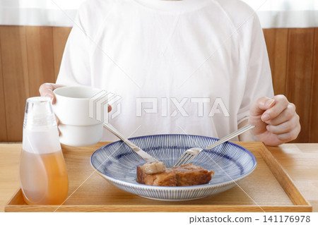 A woman drinking a beverage during a meal A woman drinking a beverage during a meal 141176978