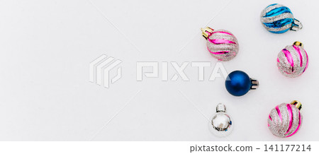 Colorful Christmas baubles scattered on a white background with copy space. Holiday decoration for seasonal branding, greeting cards and festive product design. Colorful Christmas baubles scattered on a white background with copy space. Holiday decoration for seasonal branding, greeting cards and festive product design. 141177214