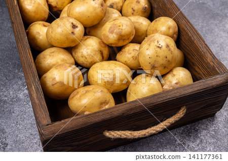 Fresh organic potatoes in old rustic wooden box Fresh organic potatoes in old rustic wooden box 141177361