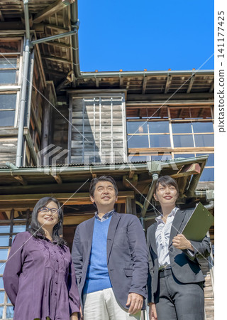 A businesswoman and a senior couple giving a tour of an old house A businesswoman and a senior couple giving a tour of an old house 141177425