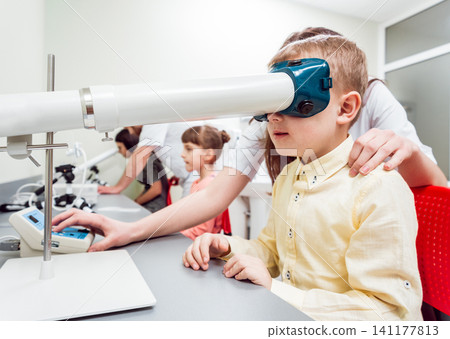 Orthoptics. Pleoptics. Doctor explains how to use ophthalmic equipment. Eye training. Vision rehabilitation. Orthoptics. Pleoptics. Doctor explains how to use ophthalmic equipment. Eye training. Vision rehabilitation. 141177813