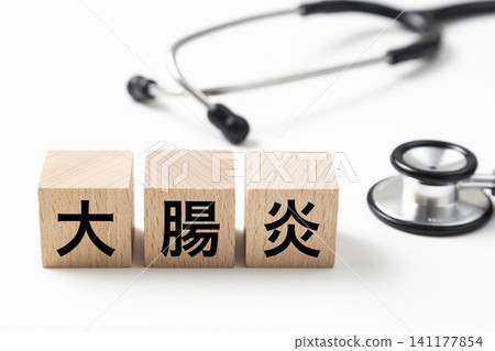 一塊標示「結腸炎」的積木和一個聽診器。 一塊標示「結腸炎」的積木和一個聽診器。 141177854