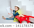Little girl with wheelbarrow on the white background. Construction 141178374