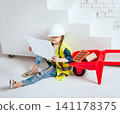 Little girl with wheelbarrow on the white background. Construction 141178375