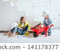 Little girl and boy with wheelbarrow on the white background. Construction 141178377