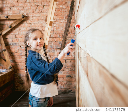 Little girl in a room with a wooden wall. Construction Little girl in a room with a wooden wall. Construction 141178379