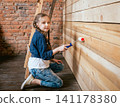 Little girl in a room with a wooden wall. Construction 141178380
