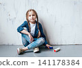 Little girl in a room with a wooden wall. Construction 141178384