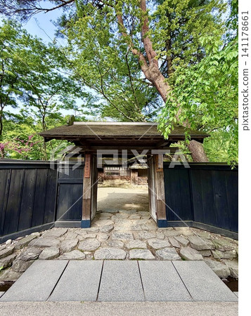 The gate of the Iwahashi family residence (Yakui-mon gate and black wooden fence) is adorned with a blue sky and fresh greenery. <Samurai Residence Street / Kakunodate-cho, Semboku City, Akita Prefecture> The gate of the Iwahashi family residence (Yakui-mon gate and black wooden fence) is adorned with a blue sky and fresh greenery. <Samurai Residence Street / Kakunodate-cho, Semboku City, Akita Prefecture> 141178661